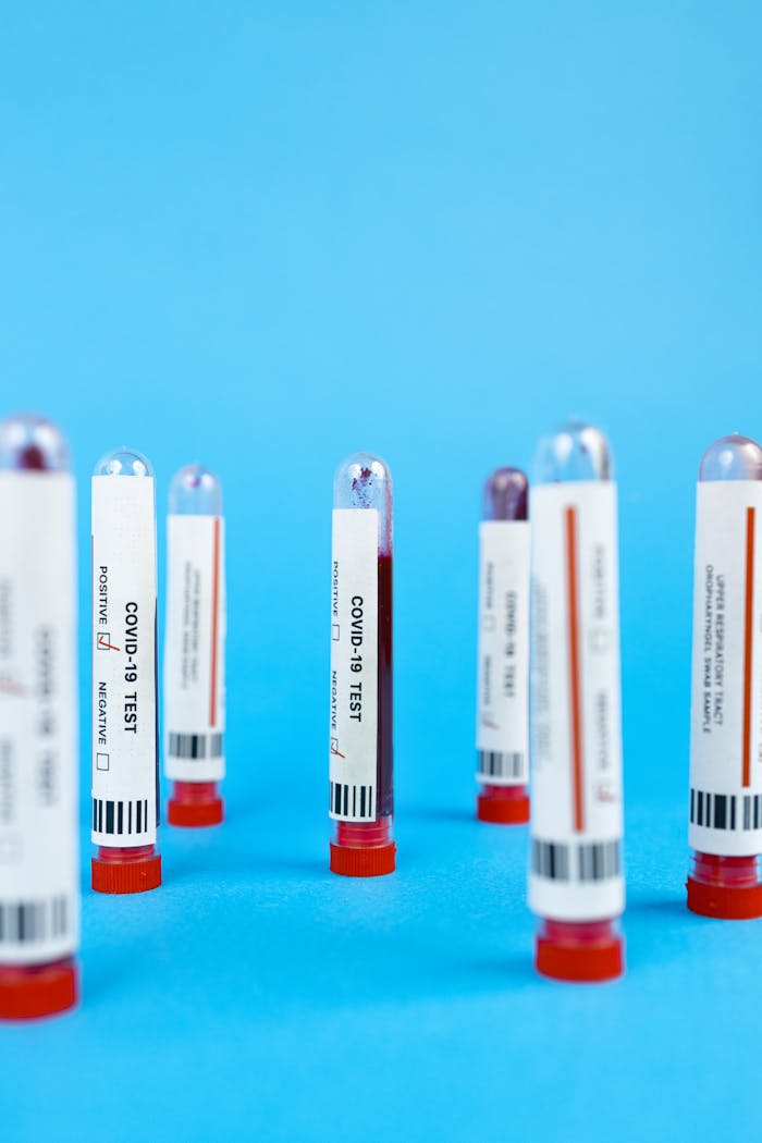 Close-up of COVID-19 blood test tubes on a blue background in a studio setup.